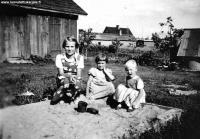 Kesällä Enson Pellervontiellä Eeva-Riitta ja Maija -Liisa hiekkalaatikolla (Arposia) Isompi tyttö on serkku Hilkka Viskari.
